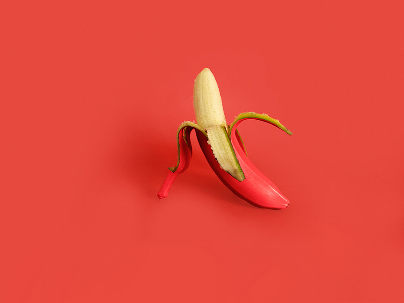 Rote Banane auf rotem Hintergrund