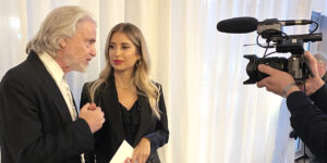 Hermann Bühlbecker und Cathy Hummels bei einem Interview. Rechts ist eine Kamera zu sehen.